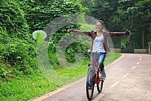 Woman cyclist fun riding bike on forest trail