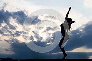 Young woman dancer on outdoor sunrise background. Concept of freedom and happy lifestyle