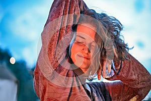 Young woman dancing in the light of fire at dusk