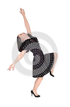 A young woman dancing in a pock dot dress