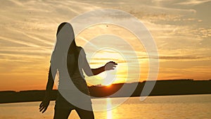 Young woman dancing at a sunset party. Free and cheerful woman. Happy girl with long hair is dancing at sunset on the