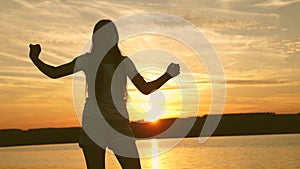 Young woman dancing at a sunset party. Free and cheerful woman. Happy girl with long hair is dancing at sunset on the