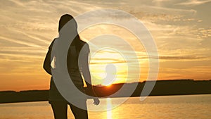 Young woman dancing at a sunset party. Free and cheerful woman. Happy girl with long hair is dancing at sunset on the