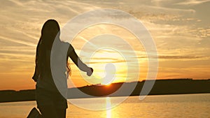 Young woman dancing at a sunset party. Free and cheerful woman. Happy girl with long hair is dancing at sunset on the