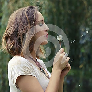 Young woman with dandelion