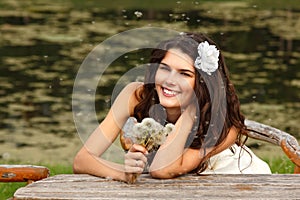 Young woman with dandelions summer outdoor, beautiful bride has