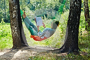 Young woman in dark sunglasses lies in hammock