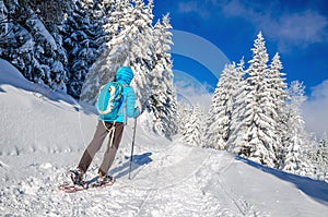 Young woman in dawn jacket hiking on snow shoes