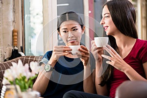 Young woman daydreaming while drinking a cup of coffee