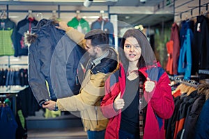 Young woman deciding on windcheater in store photo