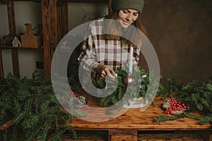 Young woman decorating Christmas flower arrangement.