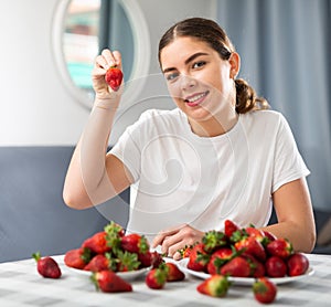 Young woman demonstrates a strawberries