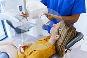 Young woman at dentist examination, doing x-ray screen of teeth.