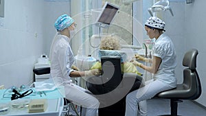 Young woman dentist, treats the teeth of a female patient. Dental treatment