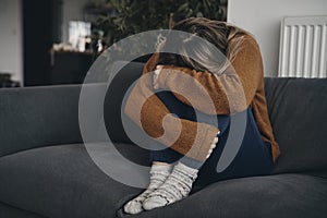 Young woman with depression siiting at the couch