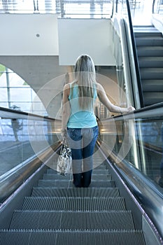 Young woman descending an escalator