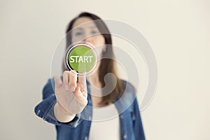 Young woman designer touching virtual button start. New start, beginning, business concept