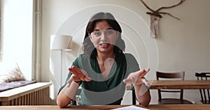 Young woman at desk makes speech to camera