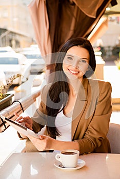 Young woman with digitale tablet and cup of coffee in cafe