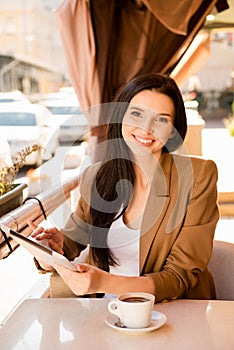 Young woman with digitale tablet and cup of coffee in cafe photo