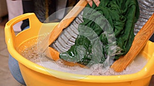 Young woman diligently washes clothes by hand using washboard