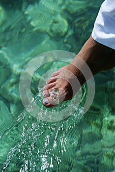 Young woman dipping toes in water