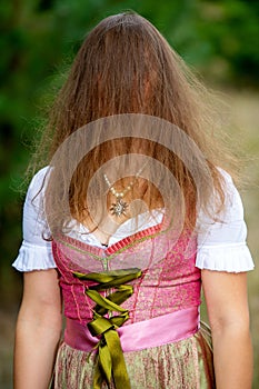 Young woman in dirnld hiding her face behind her hair