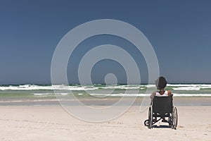 Young woman disable sitting on wheelchair at beach