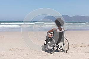 Young woman disable sitting on wheelchair at beach