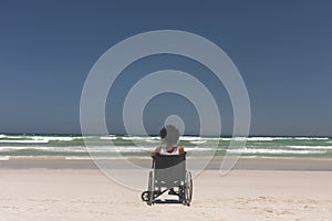 Young woman disable sitting on wheelchair at beach