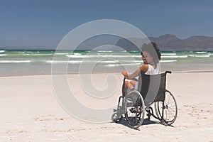 Young woman disable sitting on wheelchair at beach