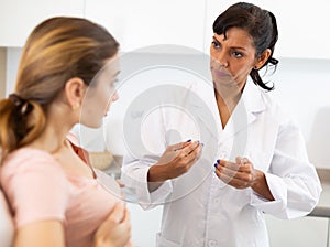 Young woman discussing breast augmentation with female doctor