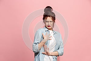 Young woman with disgusted expression repulsing something, isolated on the pink