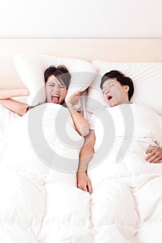 Young woman disturbed by the snores of her husband