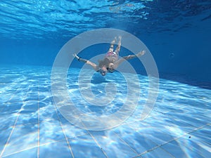 Young woman diving in the swimming pool
