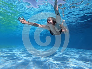 Young woman diving in the swimming pool