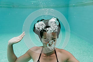 Young woman diving underwater in a pool. summer and fun lifestyle