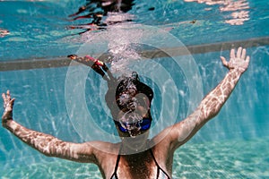 Young woman diving underwater in a pool. summer and fun lifestyle