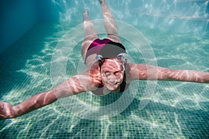 Young woman diving underwater in a pool. summer and fun lifestyle