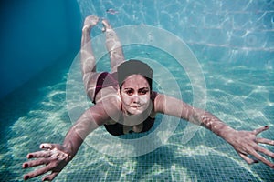 Young woman diving underwater in a pool. summer and fun lifestyle