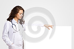 Young woman doctor with a blank banner