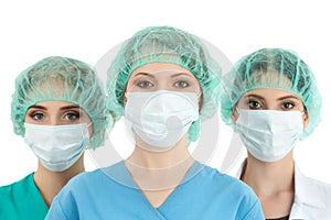 Young woman doctor in cap and face mask with two her collegues