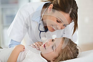 Young woman doctor examining little girl'ear