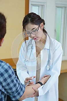 Young woman doctor giving male patient injection