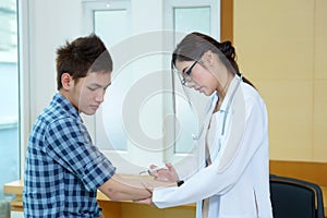 Young woman doctor giving male patient injection