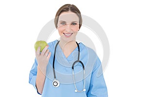 Young woman doctor holding a green apple