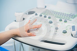 Young woman doctor`s hands close up preparing for an ultrasound device scan.