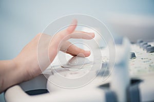 Young woman doctor`s hands close up preparing for an ultrasound device scan.