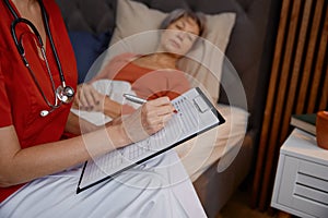 Young woman doctor visiting elderly woman patient in retirement house