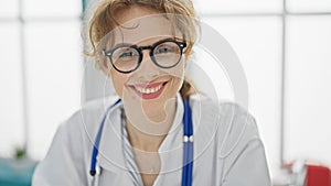 Young woman doctor wearing glasses smiling at the clinic